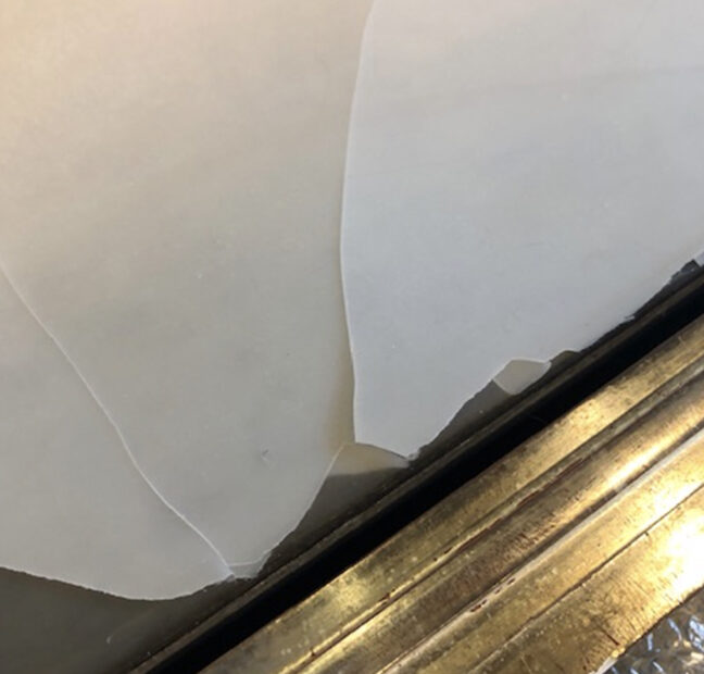 Encaustic wax delaminating from the surface of an artwork